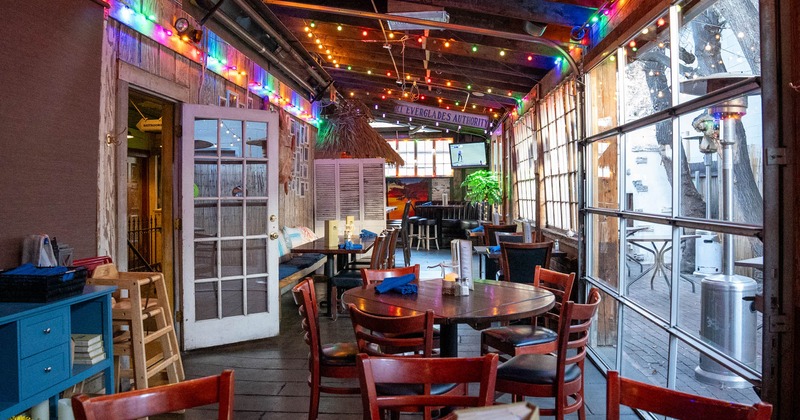 Interior, covered patio, waiter serving station, various chairs and tables, large windows