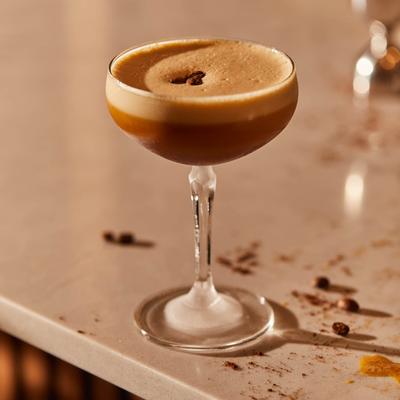 Espresso Martini on a bar counter with coffee beans.