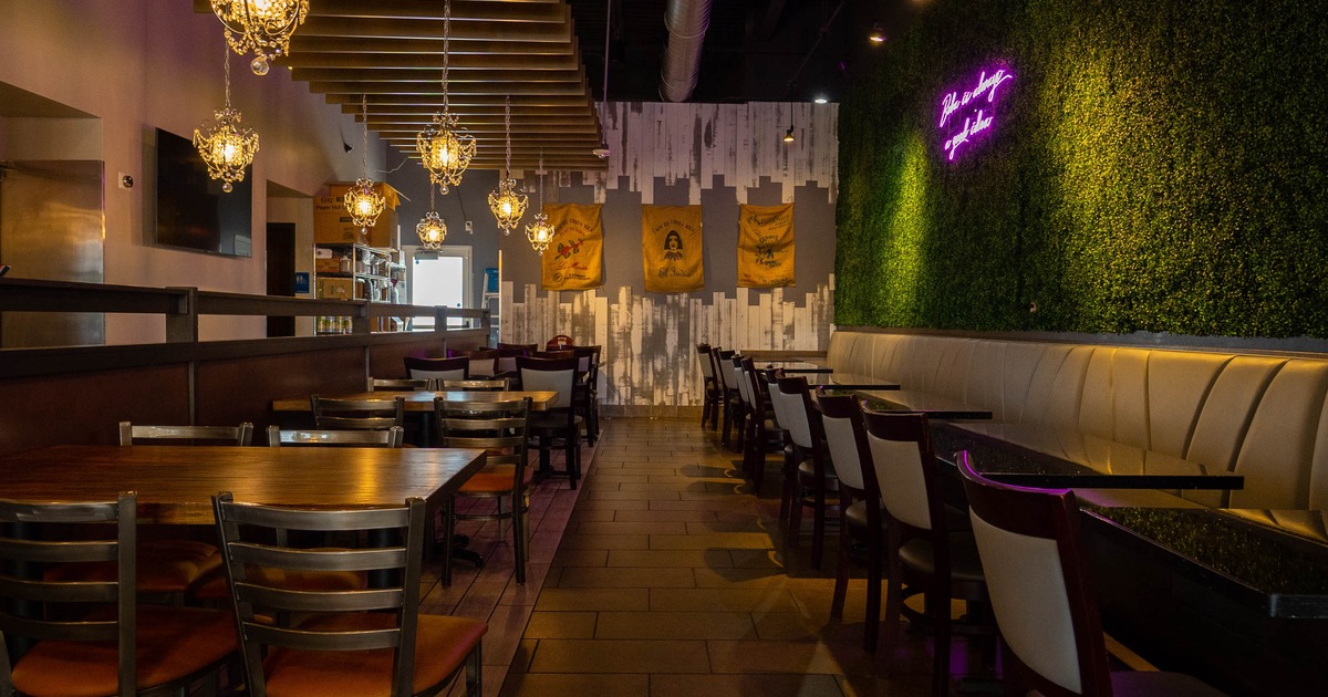 Interior view of a restaurant featuring wooden tables and chairs, chandeliers