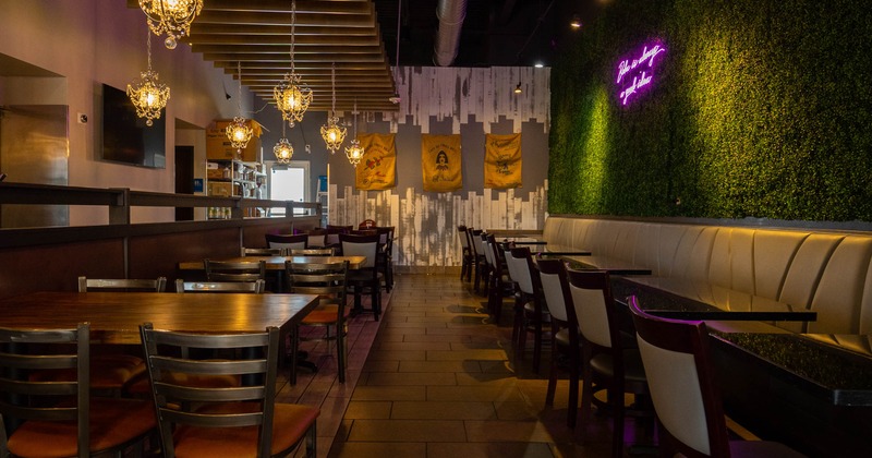 Interior view of a restaurant featuring wooden tables and chairs, chandeliers
