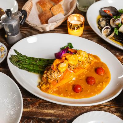 Seared salmon crusted with crab meat, served with shrimp and mango sauce, and grilled asparagus.