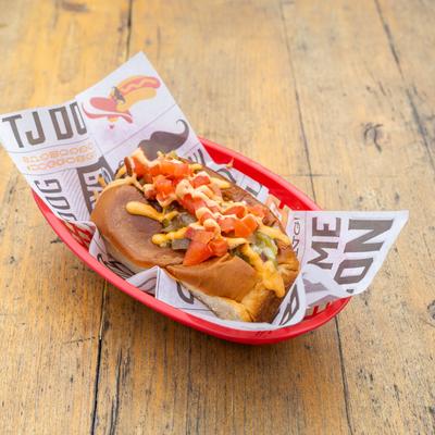 Bacon-wrapped hotdog stuffed in a chile verde, grilled onions, tomato and chipotle