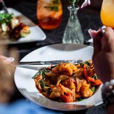 Over-the-shoulder shot of a person eating Nola Shrimp and Grits