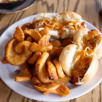 Smoked hot dogs served with curly fries.