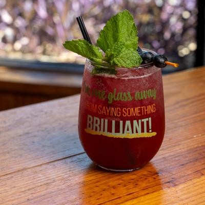 A refreshing, dark berry cocktail served in a funny stemless wine glass.