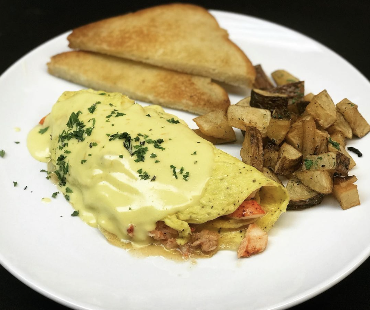 Lobster Omelette, smothered in hollandaise sauce, with toast and breakfast potatoes