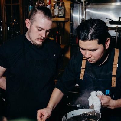 Chef drizzling sauce over dishes.