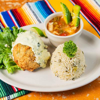 Deep fried, stuffed avocado, covered in sauce, with rice, and tortilla soup on the side.