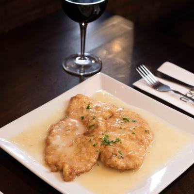 Fried chicken with white gravy, a glass of red wine.