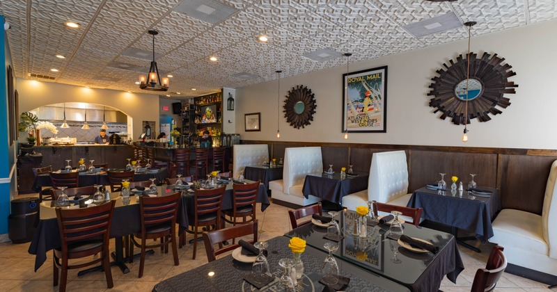 Interior - dark wood tables, yellow flowers, white booth seating and a visible bar area