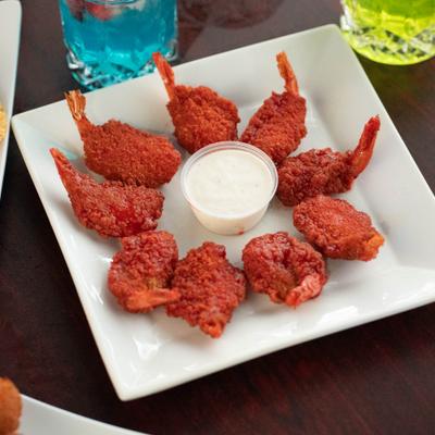 Buffalo shrimp with a dip, alongside couple of cocktails.