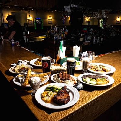 Assortment of dishes served on the bar counter alongside drinks.