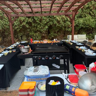 Outdoor hibachi setup under a wooden pergola.