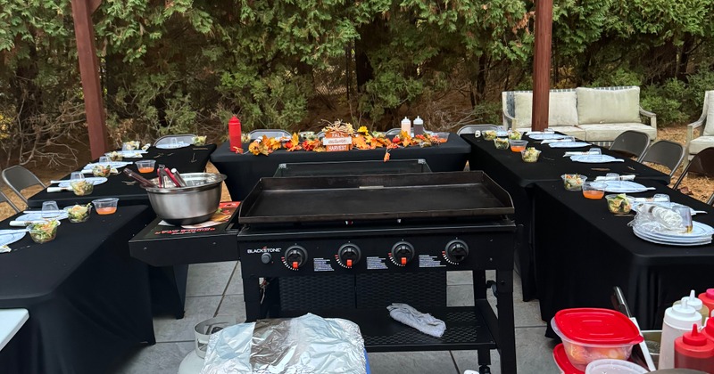 Outdoor hibachi setup under a wooden pergola