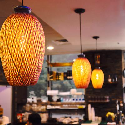 Warmly lit restaurant interior with pendant lamps hanging above.