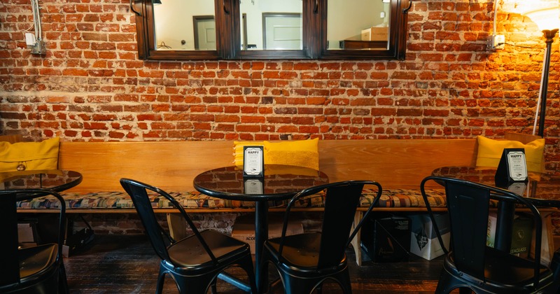 Interior with a wooden bench, tables, and black metal chairs