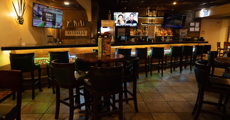 Interior, tables and stools with the bar in the back