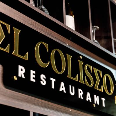 Restaurant's indoor signage featuring gold-colored lettering on a black background.