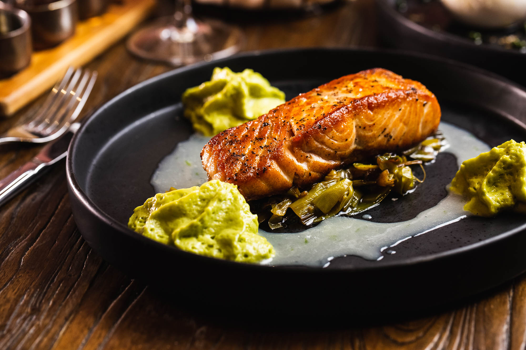 Salmon with grilled leeks, coconut and lime sauce, and spicy avocado mousse