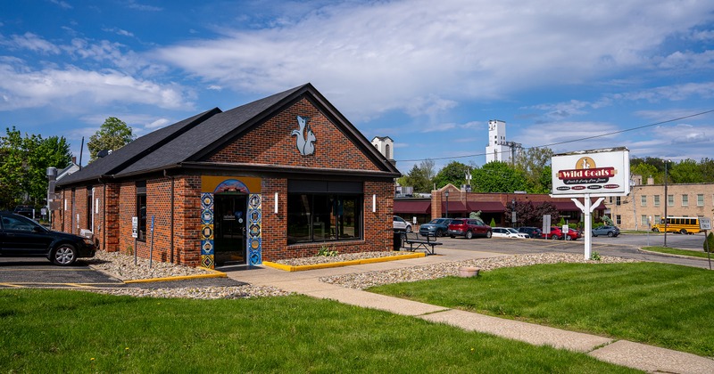 Restaurant building featuring a red brick exterior and a distinct goat mural