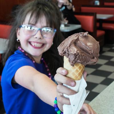 customer holding chocolate ice cream cone.
