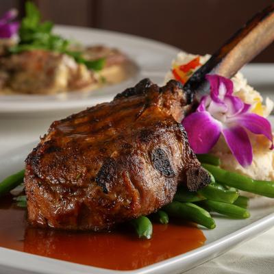 Grilled Veal Chop served with mashed potatoes and green beans.