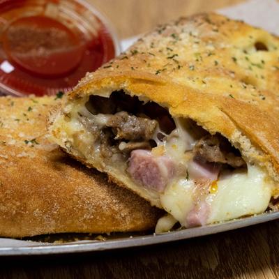 Meat Lovers stromboli served with a dip on the side.