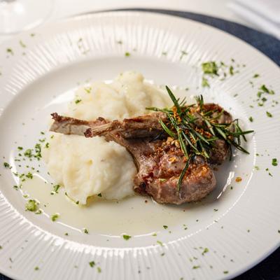 Lamb chop topped with herbs and served over mashed potatoes.
