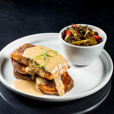 Blackened salmon, with Cajun cream sauce, thick cut potato chips, and braised kale.