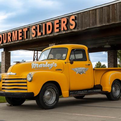 Outside, company's  yellow truck parked in front of Gourmet Sliders