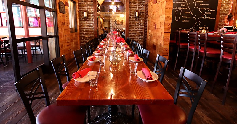Interior, dining area, long wooden top table for twenty people, ready for guests
