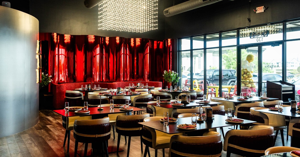 Modern interior with red and beige decor, wooden floors, and large windows.