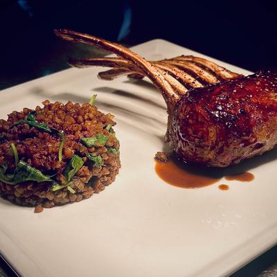 Rack of lamb served with seasoned grains.