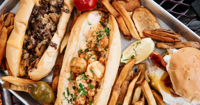 Philly sandwich, Po Boy and fries on the platter, closeup