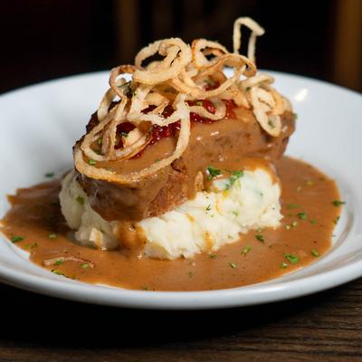 Meatloaf topped with tomato chutney and crispy onions served with mashed potatoes and gravy.