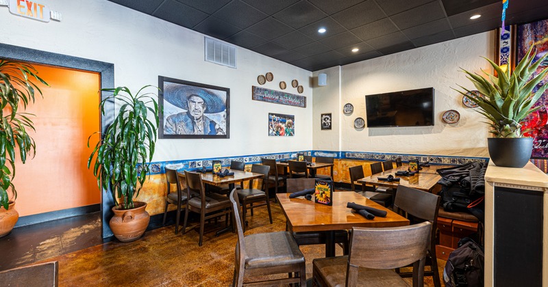 Interior, seating area with tables, chairs, TV and art on the wall