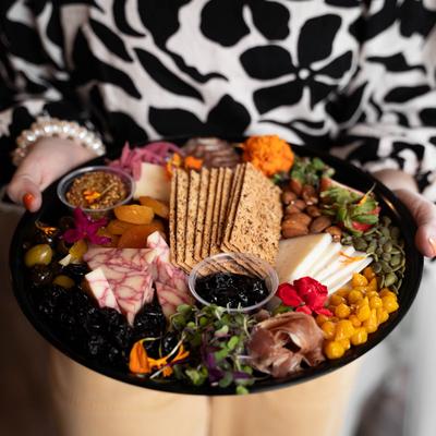 A hand holding the Charcutlerie board.