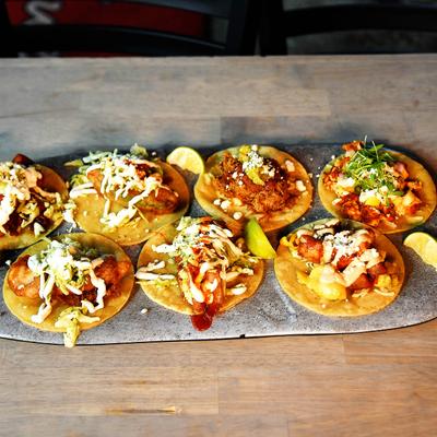 A variety of open-faced tacos on a plate.
