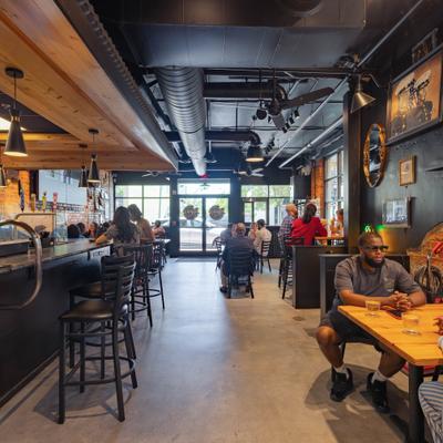 Restaurant interior featuring an industrial ceiling, wall decor, and seated guests.