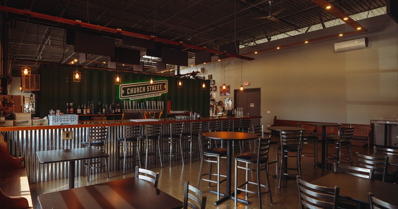 Interior, high tables and chairs near bar