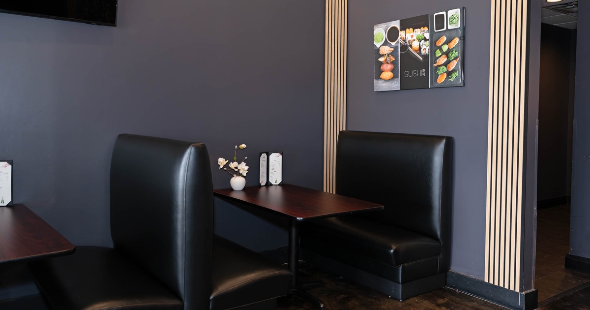 restaurant interior with dark gray walls and black leather booth seating