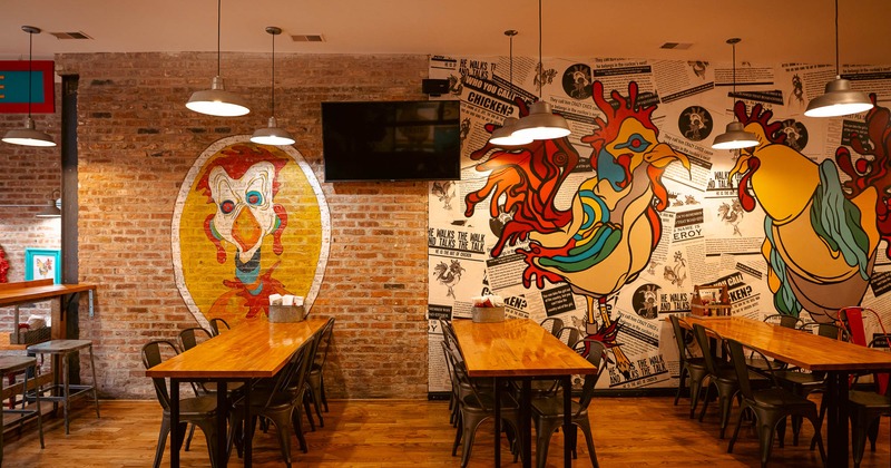 Interior, tables and chairs near decorated wall