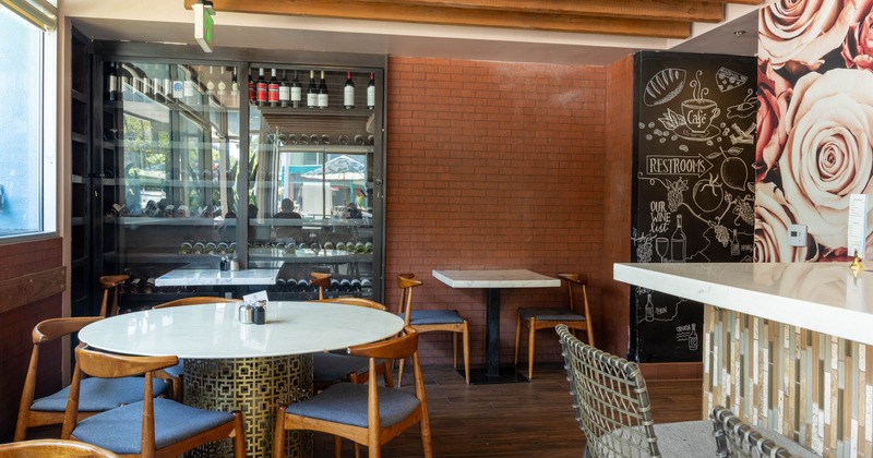 Modern interior with tables, chairs, wine cabinet and decorative wall art