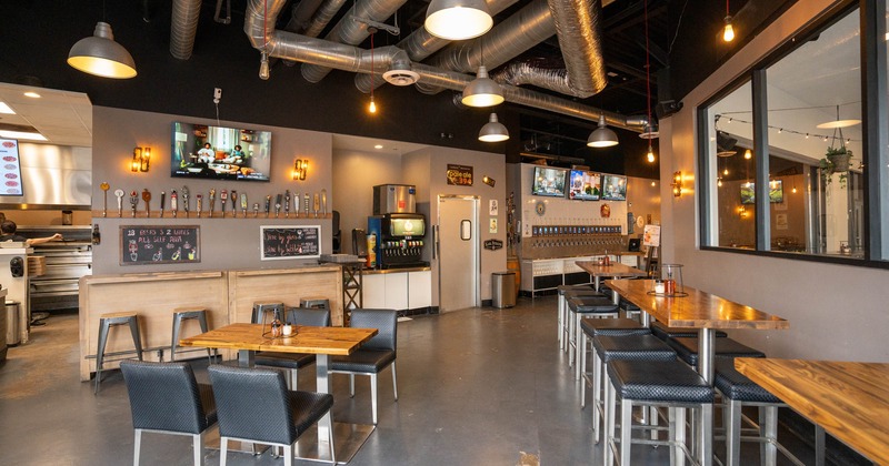 Interior, high and regular seating tables with chairs, beer tap and soda fountain stations