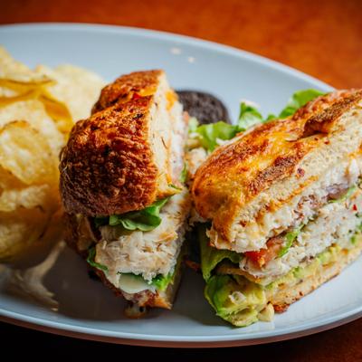 Chipotle chicken sandwich paired with kettle chips, close view.