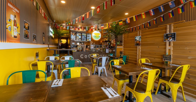 Interior with flags, wooden tables, and bright metal chairs