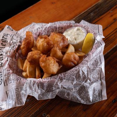 Fried scallops served with dipping sauce and fries.