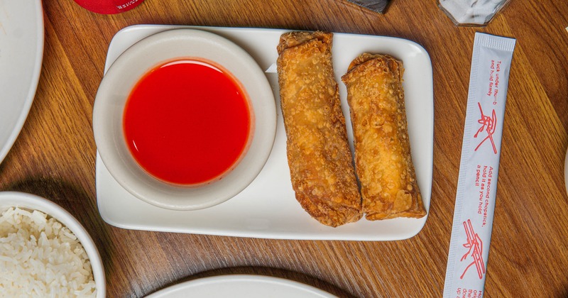 Chicken spring rolls served with a dip on the side