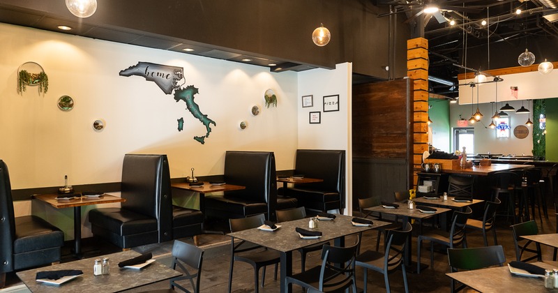 Modern and cozy interior dining area with set dining tables and upholstered booths along the wall