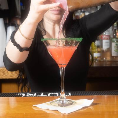 Bartender pouring a cocktail.